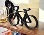 Minimal black bike line art shelf decor with candles and books, modern bicycle gift idea for cyclists, biking enthusiasts, and cycling-inspired home decor.