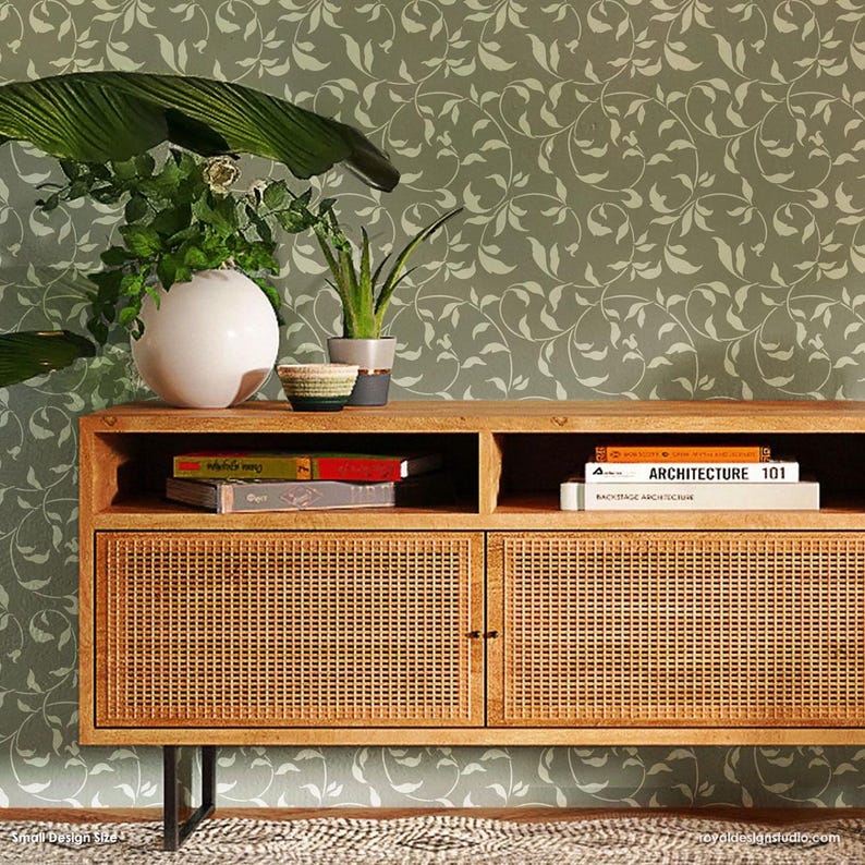 May include: A wooden cabinet with two doors and a shelf. The cabinet has a woven rattan design on the doors. The cabinet is in front of a wall with a green and white leafy vine pattern.