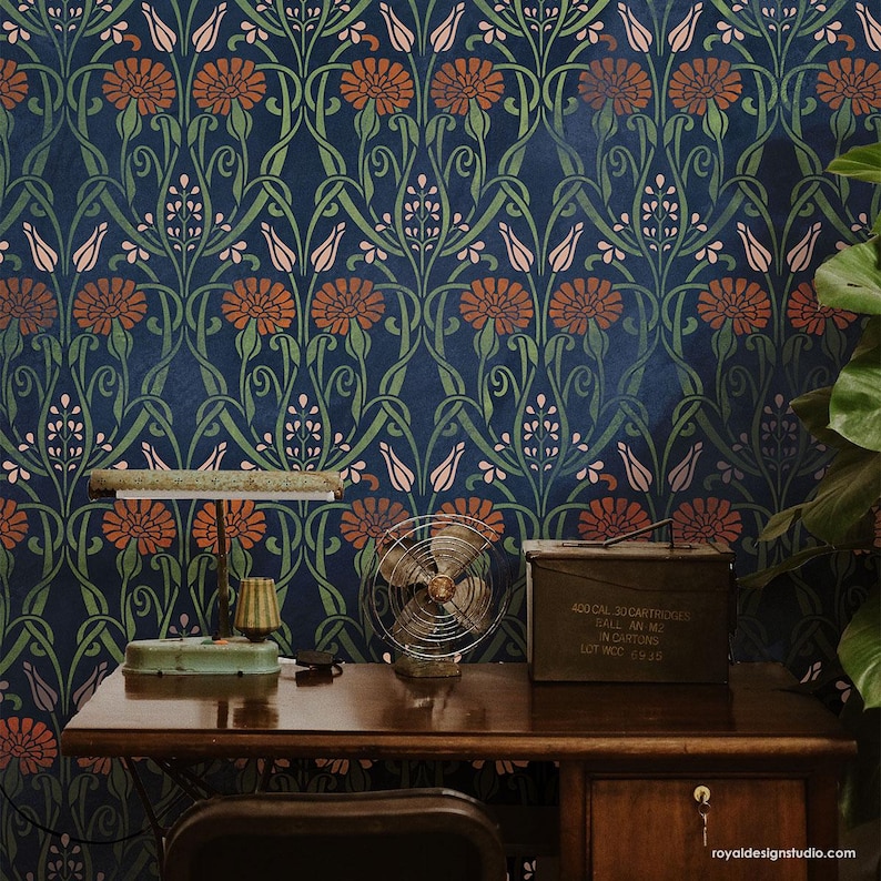 May include: A dark blue wallpaper with a repeating pattern of stylized flowers and leaves. The wallpaper is decorated with orange, pink, and green colors. A desk with a lamp, a fan, and a metal box with the text "400 CAL.30 CARTRIDGES  FILL AN ME  INCH. ROUND  LOT NO. 6745" is in front of the wallpaper.
