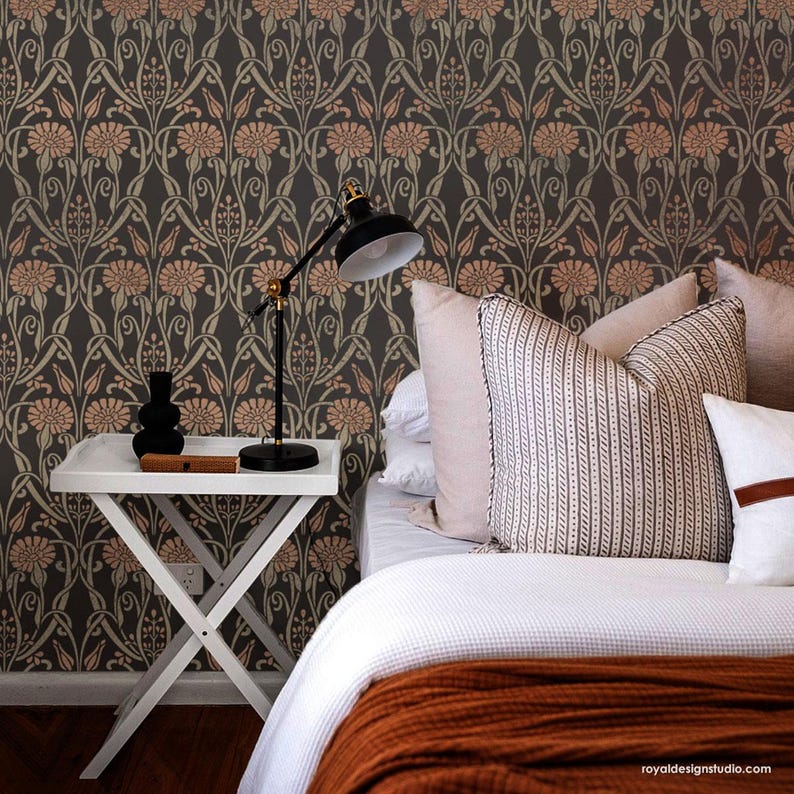 May include: A bedroom with a white bed, a brown blanket, and a white side table with a lamp. The wall is covered in a floral wallpaper pattern in shades of brown, green, and orange.
