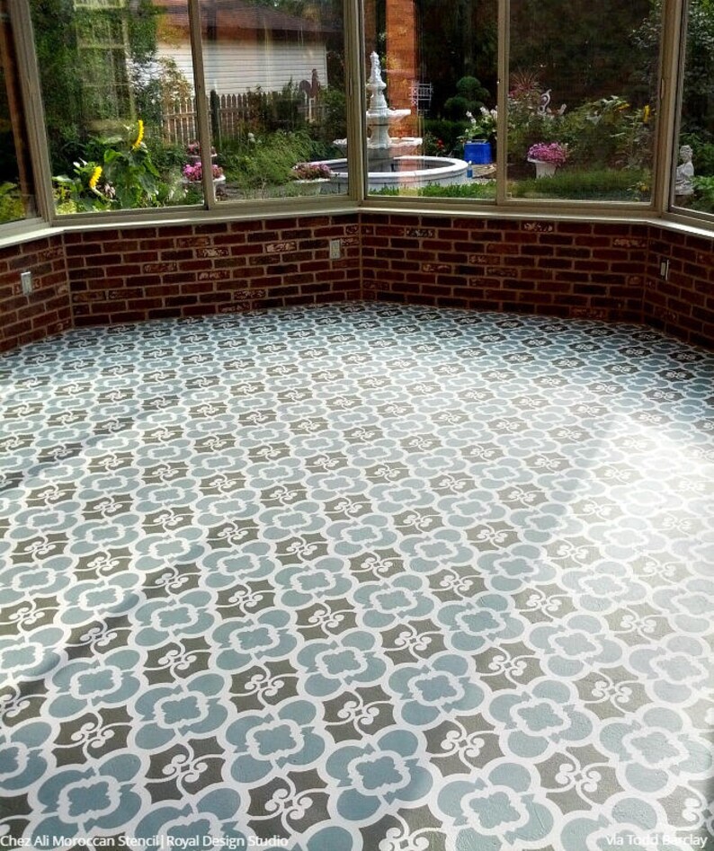 May include: A sunroom floor with a stencil design painted in gray, white, and blue. The design is a repeating pattern of interlocking shapes.