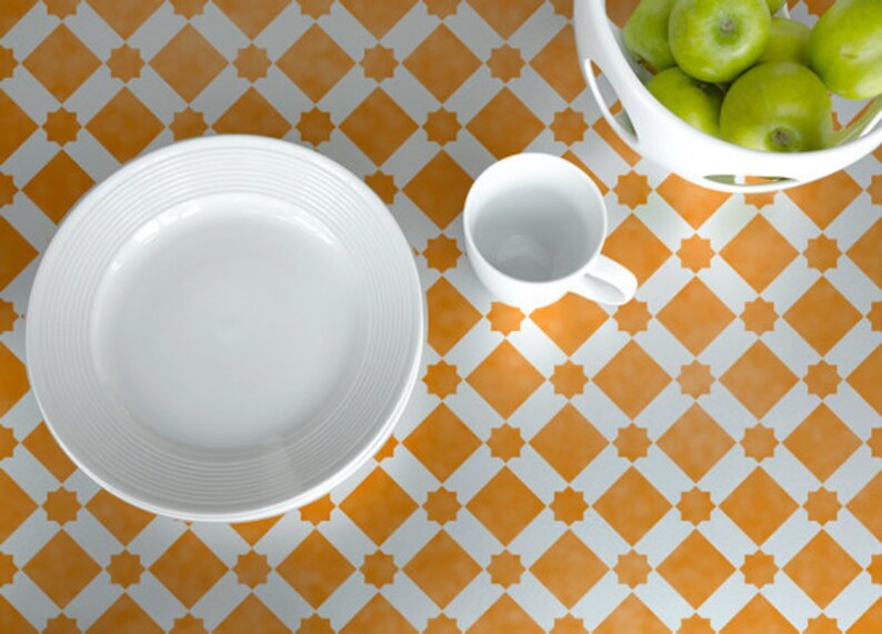 May include: A white ceramic plate and cup on a table with a yellow and white checkered pattern. The plate is stacked on top of another plate.