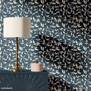 May include: A blue and white wallpaper stencil with a repeating pattern of leaves and vines. The stencil is shown on a wall with a lamp and a decorative box on a dark blue table.