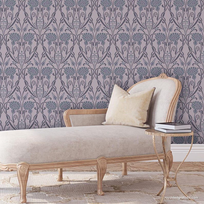 May include: A light gray chaise lounge with a pillow and a small gold side table with books on top. The chaise lounge is in front of a wall with a repeating pattern of dark gray floral designs on a light gray background.