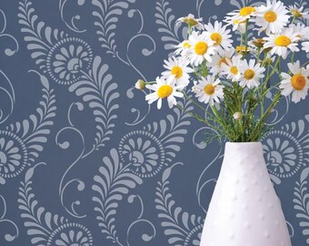 May include: A white ceramic vase with a textured surface, filled with a bouquet of white daisies with yellow centers, against a blue background with a white floral pattern.