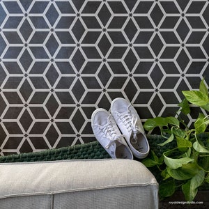 May include: A black and white geometric patterned floor with a green rug and two white sneakers. A potted plant with green leaves is in the corner.
