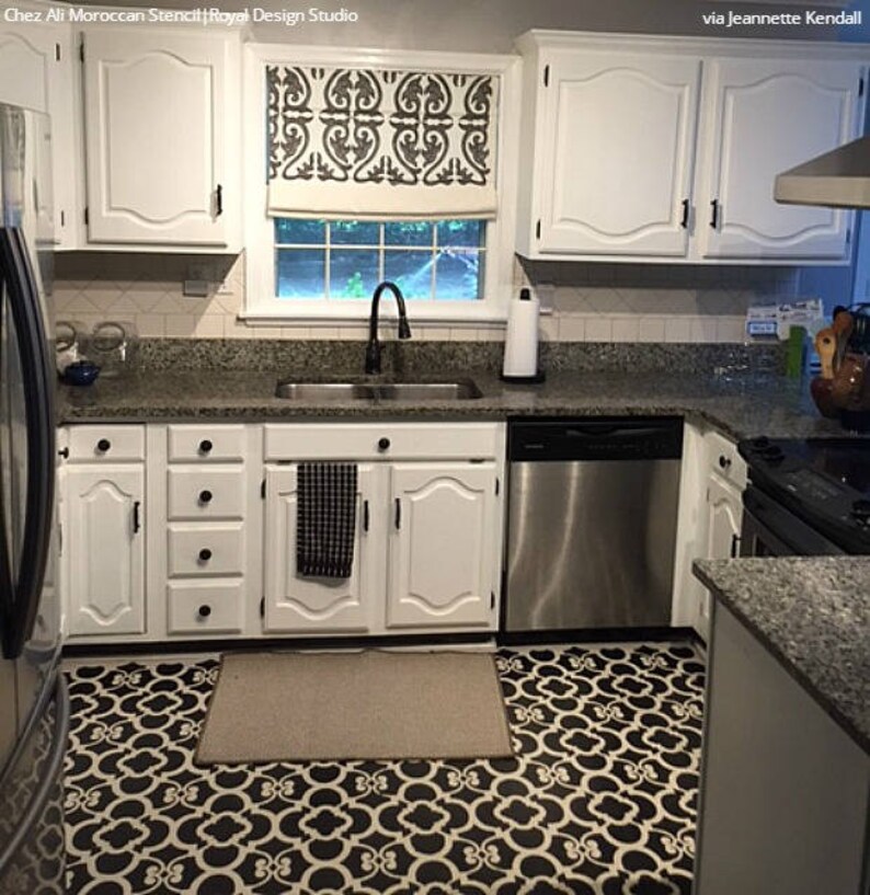 May include: A kitchen with white cabinets and a black and white patterned floor. The floor is a stencil design. The kitchen has a stainless steel dishwasher and a black and white patterned window valance.