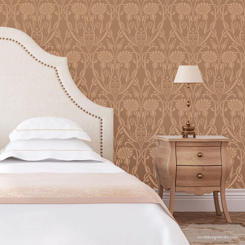 May include: A bedroom interior with a white headboard bed, white bedding, a wooden nightstand with a lamp, and a brown patterned wallpaper with a floral design.