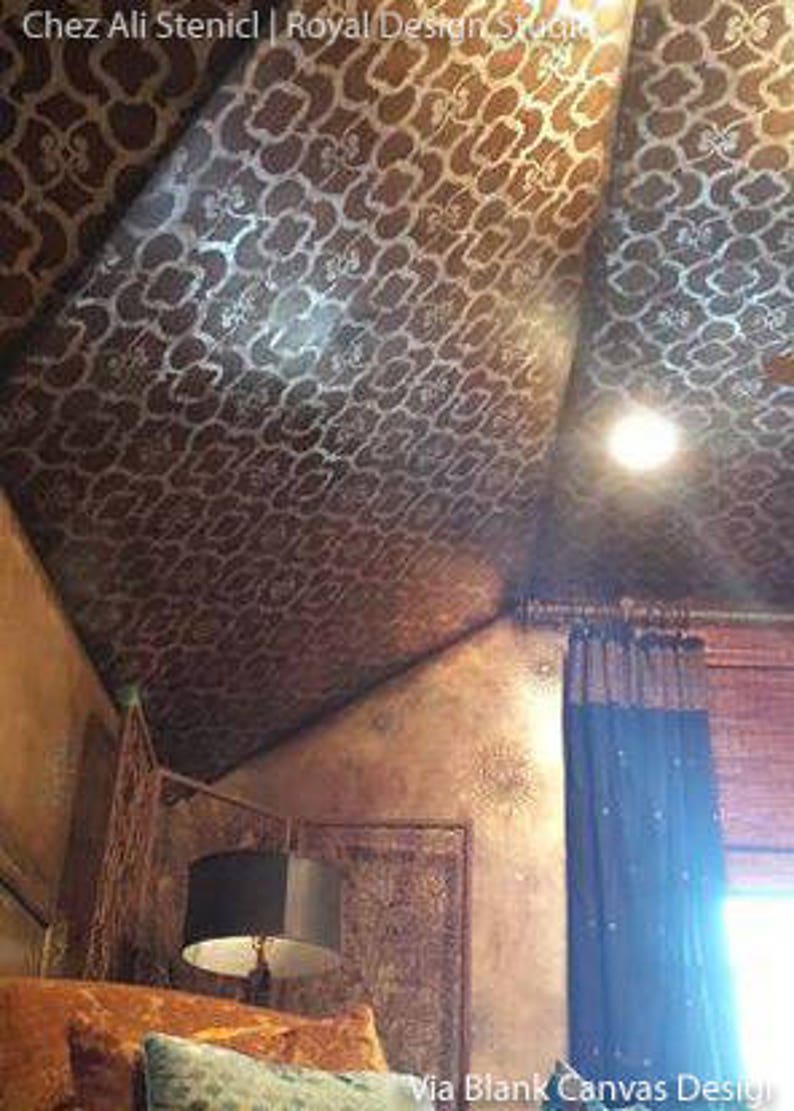 May include: A close-up of a ceiling with a decorative stencil pattern in a brown and silver color scheme. The stencil pattern is a repeating geometric design. The ceiling is angled and the room is decorated in a similar style.