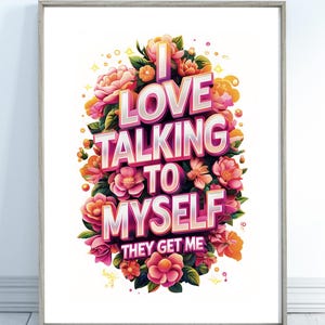 May include: A framed art print with the text "I LOVE TALKING TO MYSELF THEY GET ME" in a 3D style, surrounded by pink, orange, and yellow flowers. The artwork is set against a white background.