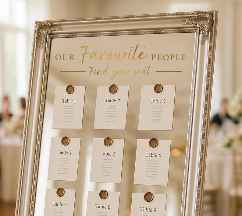May include: A silver framed seating chart with the text "OUR Favourite PEOPLE Find your seat". Nine cards are attached, each labeled "Table" followed by a number. The cards are sealed with a gold wax seal.