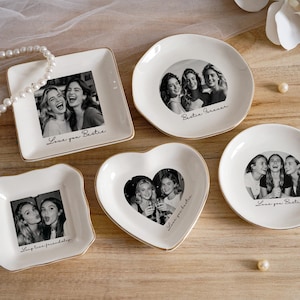 May include: A collection of white ceramic trinket dishes in various shapes, each featuring a black and white photograph of a group of friends. The dishes have gold rims and include text such as "Love you Bestie" and "Bestie Forever."