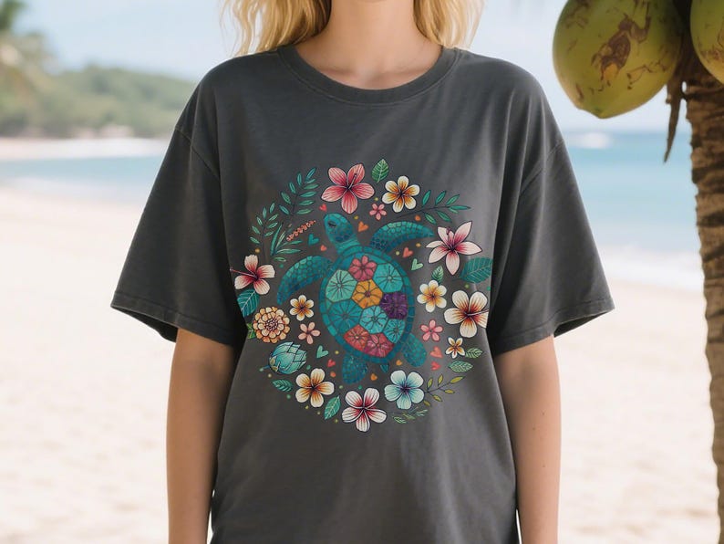 May include: Dark gray t-shirt featuring a teal turtle with a floral design. The turtle's shell is adorned with colorful flowers, surrounded by a wreath of leaves and more flowers in pink, yellow, and blue. The shirt is a casual style.