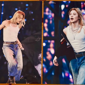 May include: Two photographic prints featuring a performer with long blonde hair wearing a white tank top, blue denim jeans with paint splatters, and a dark jacket. The left print includes the text MYLOVERJIMIN and the right print includes text.