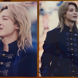 May include: Two rectangular posters featuring a person with shoulder-length blonde hair wearing a dark blue military-style jacket with gold buttons and blue embroidery. The left poster includes the text FABULOUS BOY in the upper right corner.