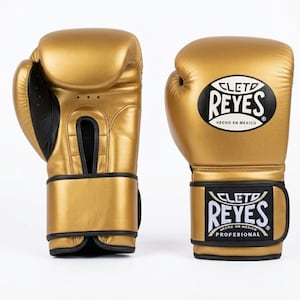 A pair of gold Cleto Reyes professional boxing gloves featuring a hook-and-loop closure, black inner thumb, and iconic branding.