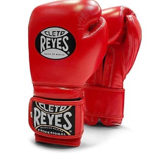 Red Cleto Reyes professional boxing gloves featuring a hook-and-loop closure, white inner thumb, and iconic branding, showcased in a dynamic 3D view on a white background.