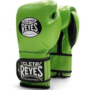 Green Cleto Reyes professional boxing gloves featuring a hook-and-loop closure, white inner thumb, and iconic branding, showcased in a dynamic 3D view on a white background.