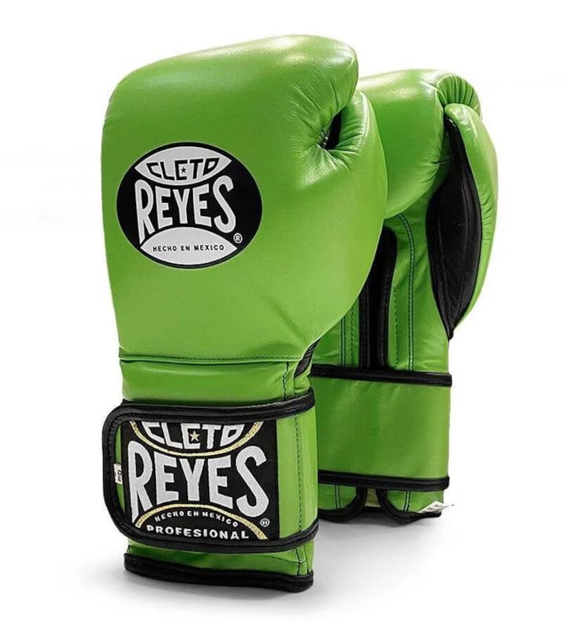 Green Cleto Reyes professional boxing gloves featuring a hook-and-loop closure, white inner thumb, and iconic branding, showcased in a dynamic 3D view on a white background.