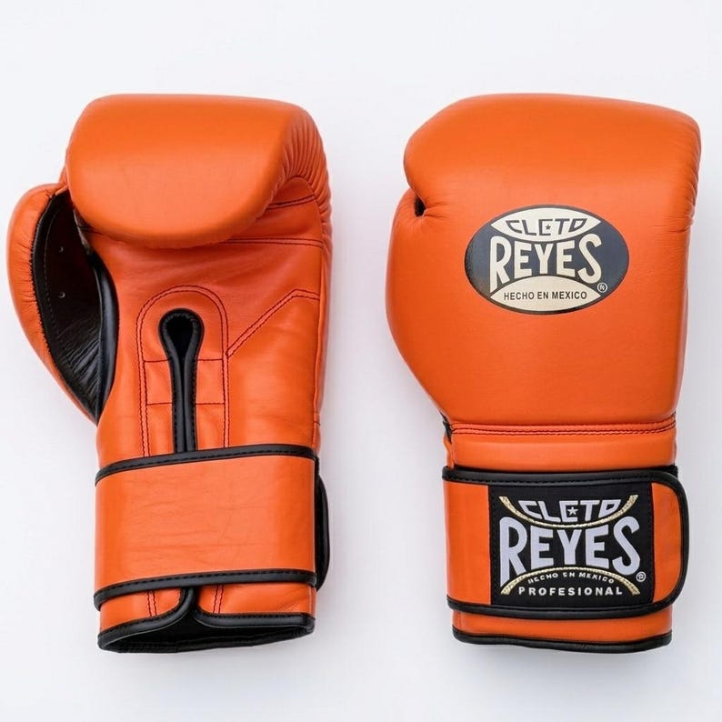 A pair of Orange Cleto Reyes professional boxing gloves featuring a hook-and-loop closure, Black inner thumb, and iconic branding.