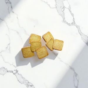 May include: A white ceramic mug with a black handle and the text "But First, Coffee" in a black, handwritten-style font. The mug is on a white surface.