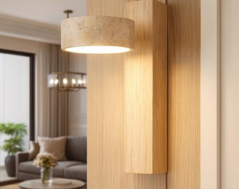 May include: A modern wall sconce with a cylindrical lampshade made of textured, light-colored material. The sconce is mounted on a vertical wooden beam, and the warm light illuminates the surrounding wooden paneling. The overall design is minimalist and contemporary.