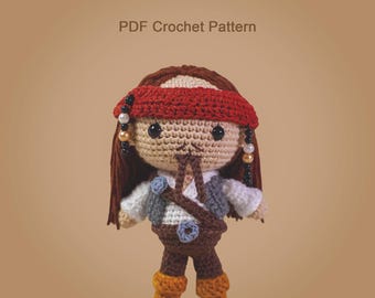 Könnte beinhalten: Gehäkelte Piratenpuppe mit rotem Bandana, braunem Haar und Weste. Die Puppe hat ein hellbraunes Gesicht mit schwarzen Augen und trägt eine braune Hose und Stiefel. Der Text "PDF Crochet Pattern" steht über der Puppe.