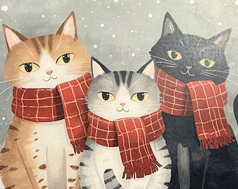 以下が含まれることがあります： 雪の中に座る3匹の猫のイラスト。茶色のトラ猫、グレーと白のトラ猫、黒猫がそれぞれ、フリンジ付きの赤いチェック柄のマフラーを巻いています。背景は柔らかなグレーで、白い雪が降っている様子が描かれています。