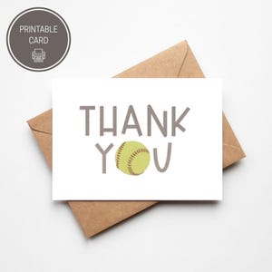 Può includere: Una carta bianca con le parole "THANK YOU" in lettere grigie, con una palla da softball che sostituisce la "O". La carta è su una busta marrone. Un cerchio grigio con "PRINTABLE CARD" e un'icona della stampante si trova nell'angolo in alto a sinistra.