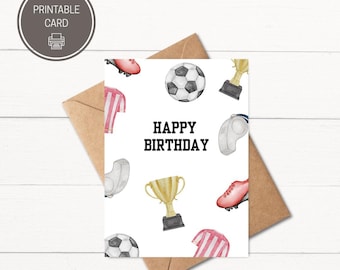 May include: A printable birthday card with a soccer theme. The card features soccer balls, cleats, trophies, and jerseys. The words "HAPPY BIRTHDAY" are in bold black letters. The card is placed on a brown envelope.