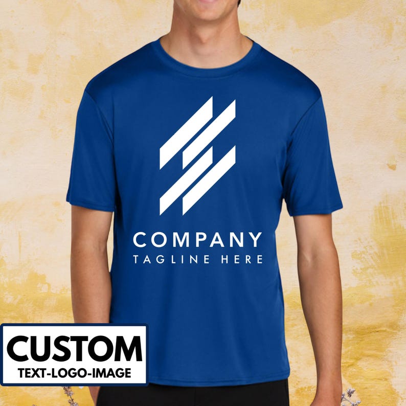 May include: Royal blue short-sleeve t-shirt with a white geometric logo and the text "COMPANY TAGLINE HERE". The shirt also has a white rectangle with the word "CUSTOM" and the text "TEXT-LOGO-IMAGE".
