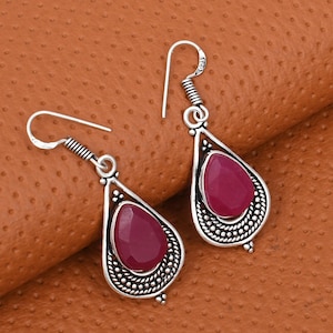 May include: A white ceramic mug with a black handle and the text "But First, Coffee" in a black, handwritten-style font. The mug is on a white surface.