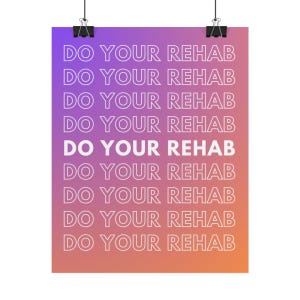 May include: A poster with the text "DO YOUR REHAB" in white, repeated vertically against a gradient background of purple, pink, and orange. The poster is held by two black binder clips.