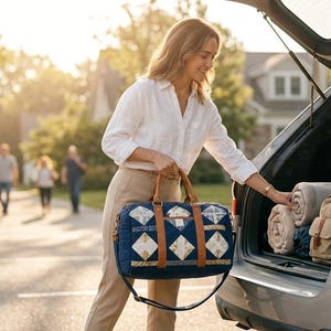 Könnte beinhalten: Eine Frau belädt den Kofferraum eines Autos mit Decken und einer blau gesteppten Reisetasche mit Rauten- und geometrischen Mustern. Die Tasche hat braune Ledergriffe und einen Schultergurt. Die Szene spielt sich im Freien an einem sonnigen Tag ab.