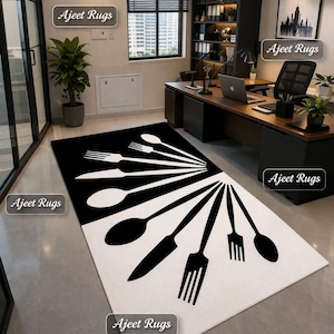May include: A rectangular black and white rug with a bold design of stylized cutlery. The rug features forks, spoons, and knives radiating from the centre, creating a striking visual pattern. The rug is placed in an office setting.