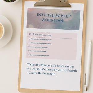 May include: A wooden clipboard holds an "Interview Prep Workbook" with a checklist and quote. The workbook has a watercolour-style header and a pink section for the checklist. A pen and a small potted plant are also in the image.