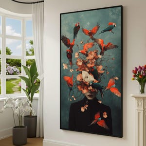 May include: A framed vertical wall art print featuring a person in a black high-neck garment with a head obscured by a cluster of orange flowers and numerous flying red, orange, and blue parrots against a dark teal, textured background.