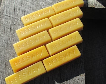 May include: A stack of eight yellow beeswax blocks, each with the word "Beeswax" printed on the front.