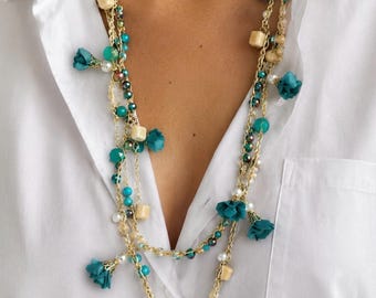Lange, gehäkelte Boho-Chic-Halskette mit türkisfarbenen und goldenen Kristallen und Stoffblumen. Nickelfrei. BURUCOCCA