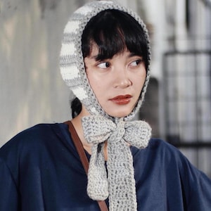 Puede incluir: Un letrero de madera hecho a mano con la palabra "Bienvenido" en una fuente juguetona. El letrero está pintado de blanco con un acabado envejecido y presenta un diseño floral en tonos rosas y verdes. Mide aproximadamente 30 cm de ancho.