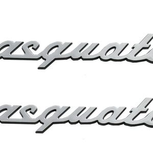 May include: Two chrome-colored "Sasquatch" script emblems. The word is in a cursive font with a black outline, set against a white background. The emblems are identical and horizontally aligned.