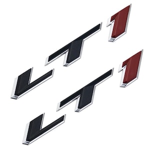 Pode incluir: Um conjunto de emblemas metálicos para carros. Os emblemas incluem a letra "V" e o número "1". Os emblemas "V" são pretos com uma borda prateada. Os emblemas "1" são vermelhos com uma borda prateada. Todos os emblemas têm um acabamento brilhante.