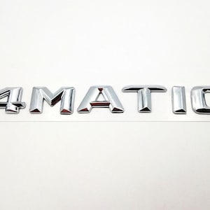 Puede incluir: Emblema cromado "4MATIC" para coche, con letras individuales y reflectantes. Esta insignia automotriz está diseñada para su aplicación en vehículos. Las letras se muestran sobre un fondo blanco.