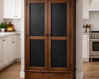 May include: A wooden cabinet with two doors and a dark chalkboard panel. The cabinet is a warm brown color and has a traditional design. The cabinet is in a kitchen setting.