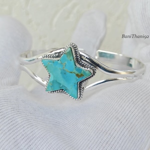 Könnte beinhalten: Ein Silberarmreif mit einem sternförmigen Türkis-Stein in der Mitte, der braune Adern aufweist. Der Stern ist von einem gedrehten Seilrand umgeben. Das Armband besteht aus zwei glatten, polierten Silberdrähten. Der Text lautet BaniThani92.