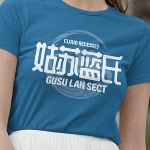 May include: Teal blue t-shirt with white Chinese characters and the English text "CLOUD RECESSES" and "GUSU LAN SECT". The shirt is worn with a white pleated skirt and sunglasses.