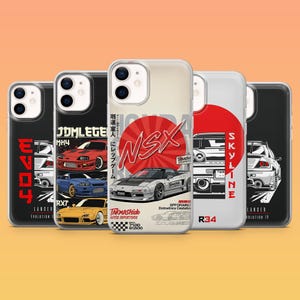 Op de afbeelding: Een verzameling doorzichtige telefoonhoesjes met auto-ontwerpen. De hoesjes tonen verschillende automodellen met tekst zoals "NSX", "SKYLINE" en "EVO". De ontwerpen gebruiken rode, witte en zwarte kleurenschema's, samen met Japanse tekst en namen van automodellen.