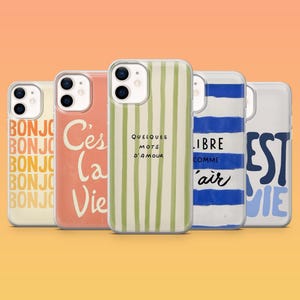 May include: Five clear phone cases with different designs. One case has vertical green stripes, another has the text "Quelques mots d'amour". Other cases feature the words "Bonjour", "C'est la Vie", "Libre comme l'air", and "Est la Vie".