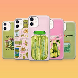 Puede incluir: Una colección de fundas para teléfonos con diseños temáticos de pepinillos. Las fundas muestran ilustraciones de pepinillos en frascos, con textos como "Peace Love and Pickles" y "pickle girlies". Las fundas son de varios colores, incluyendo rosa, verde y blanco.