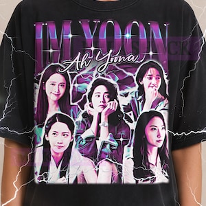 May include: Black t-shirt featuring a graphic of a woman with the text "IM YOON Ah Yoona". The design includes multiple images of the woman in a vintage style with a lightning bolt effect. The Milkshake logo is at the top.